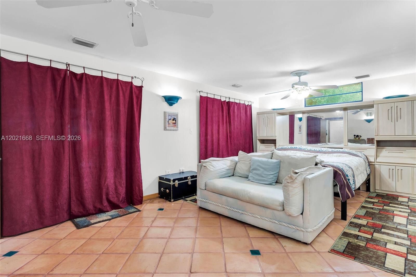 A bedroom features a bed, a sofa, maroon curtains, and light-colored tile flooring — 323 Bay View Ave, Key Largo FL 33037, KEY LARGO, FL