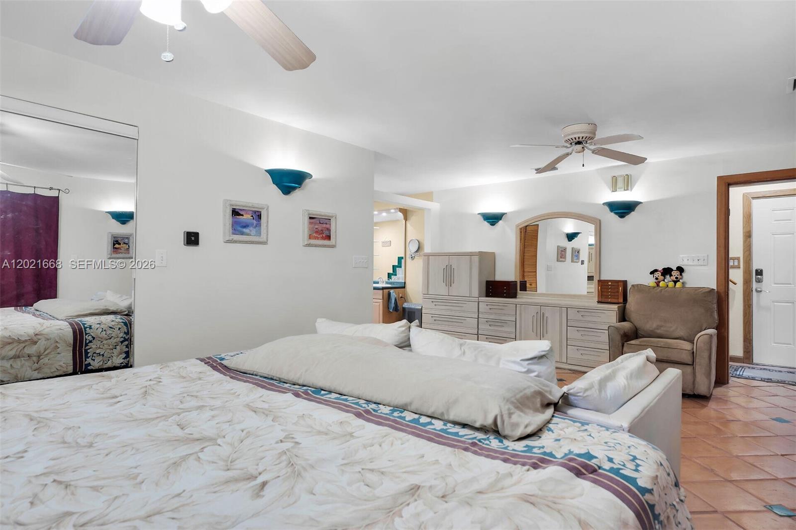A bedroom features a large bed, a dresser with a mirror, and a beige armchair — 323 Bay View Ave, Key Largo FL 33037, KEY LARGO, FL