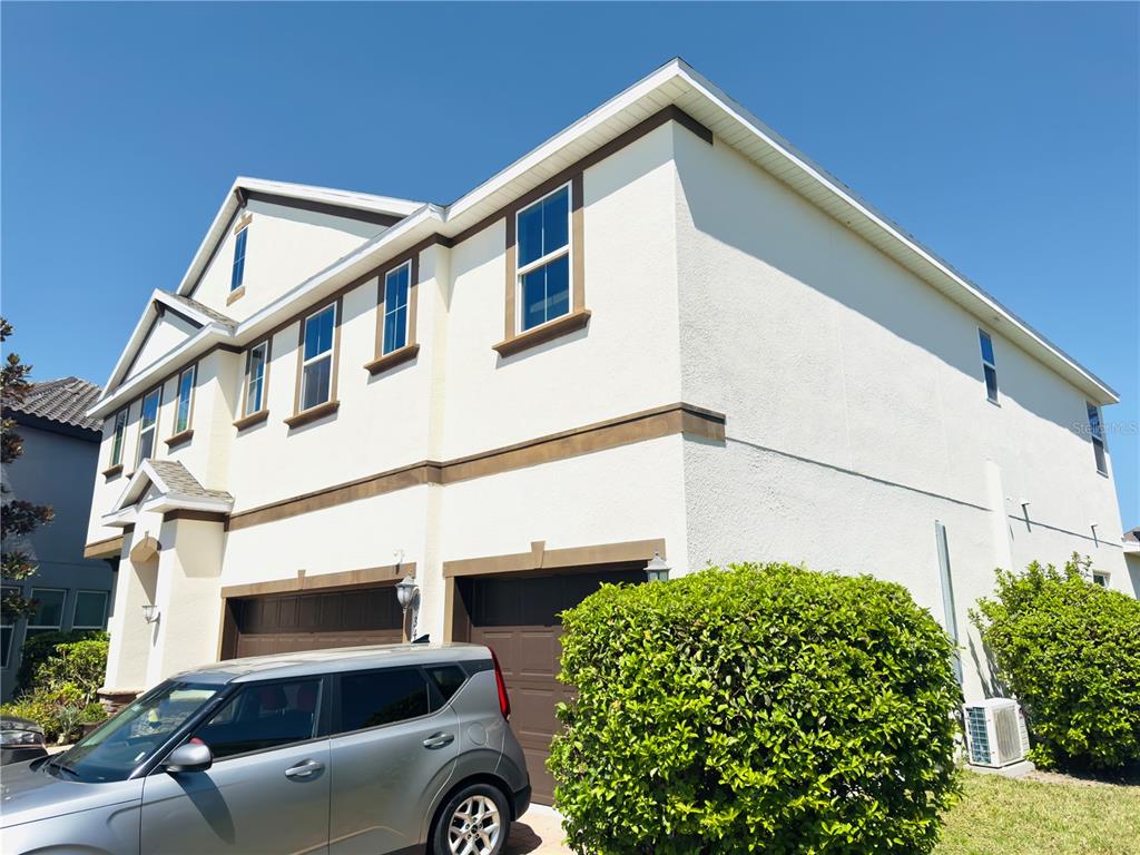 A two-story house with a beige stucco exterior, brown trim, and a two-car garage — 3436 STONEWYCK STREET, ORLANDO, FL