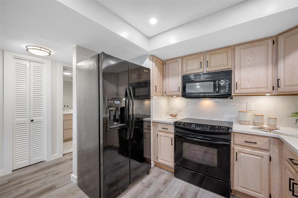 A kitchen with light wood cabinets, white countertops, and a black dishwasher — 17920 GULF BOULEVARD UNIT 2008, REDINGTON SHORES, FL