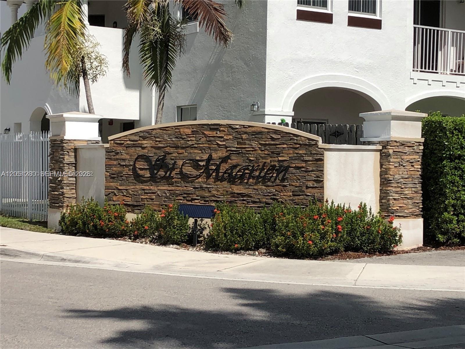 A stone monument sign with the name St. Maarten stands in front of a white building — 8760 NW 97th Ave # 205, Doral FL 33178, DORAL, FL