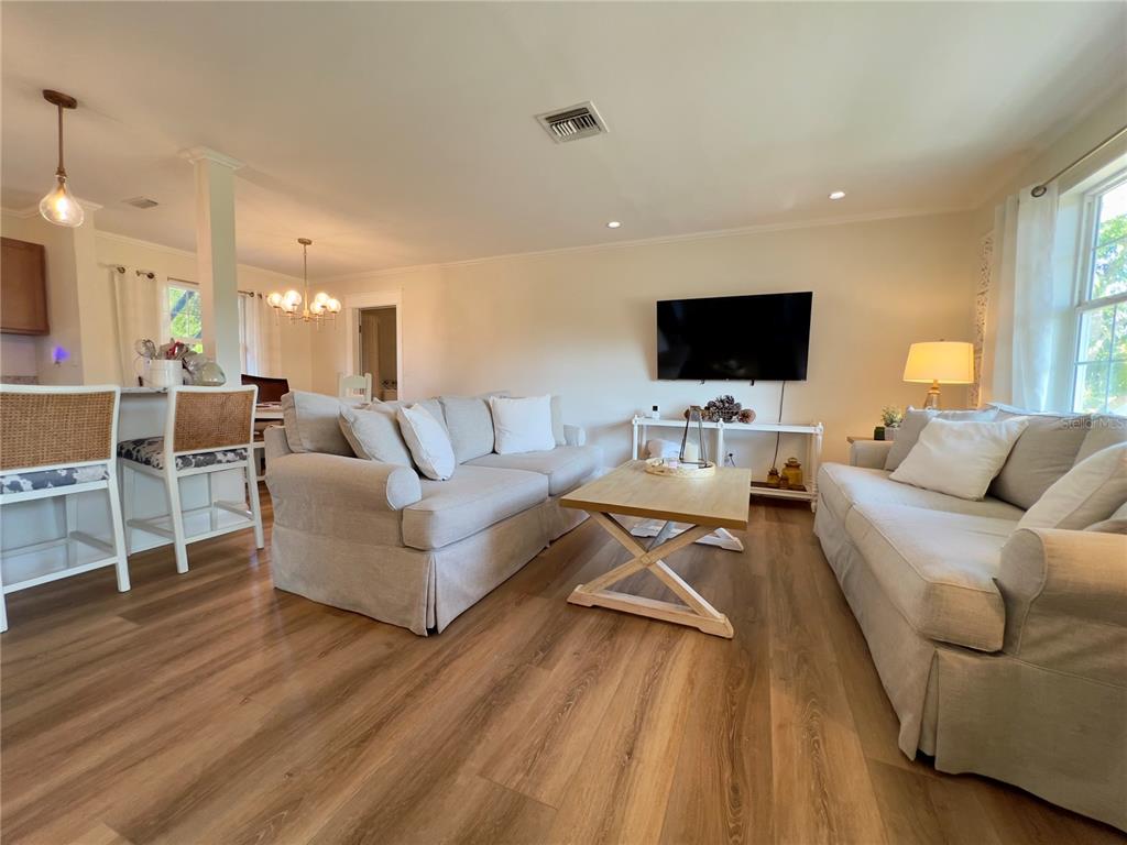 A living room features light-colored sofas, a wooden coffee table, and wood-look flooring — 4501 ROYAL PALM RANCH DRIVE, ST JAMES CITY, FL