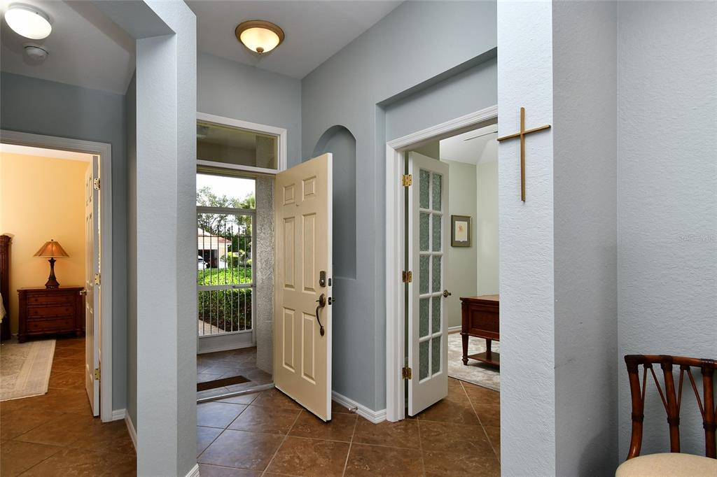 An entryway with tile floors, a light-colored front door, and a glass-paneled office door — 17900 COURTSIDE LANDINGS CIRCLE, PUNTA GORDA, FL