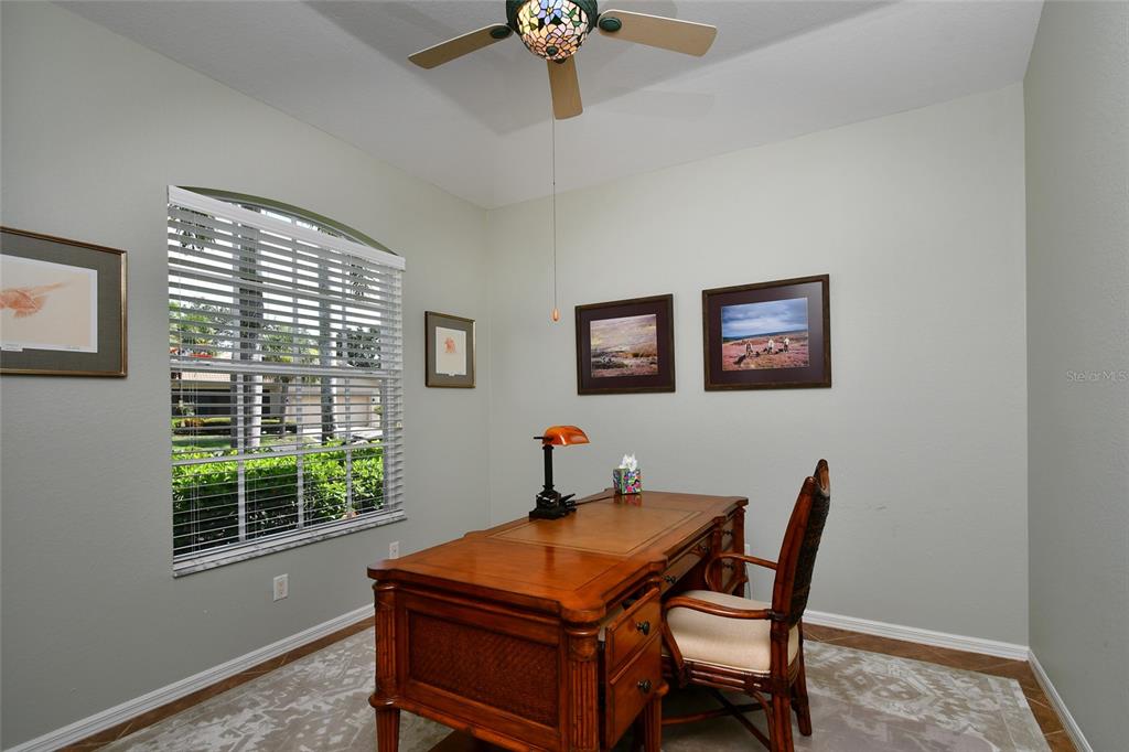 A home office features a wooden desk, a chair, wall art, and a ceiling fan — 17900 COURTSIDE LANDINGS CIRCLE, PUNTA GORDA, FL