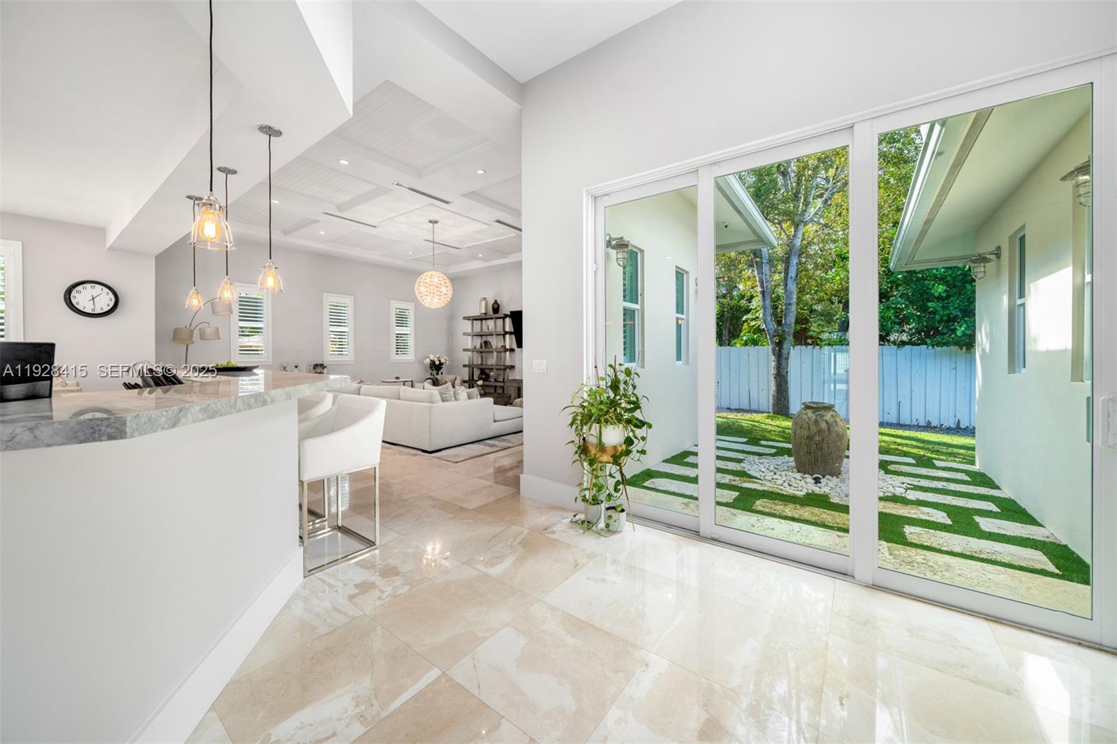A modern kitchen and living area with marble floors, pendant lighting, and glass sliding doors — 7222 SW 79th Ter, Miami FL 33143, MIAMI, FL