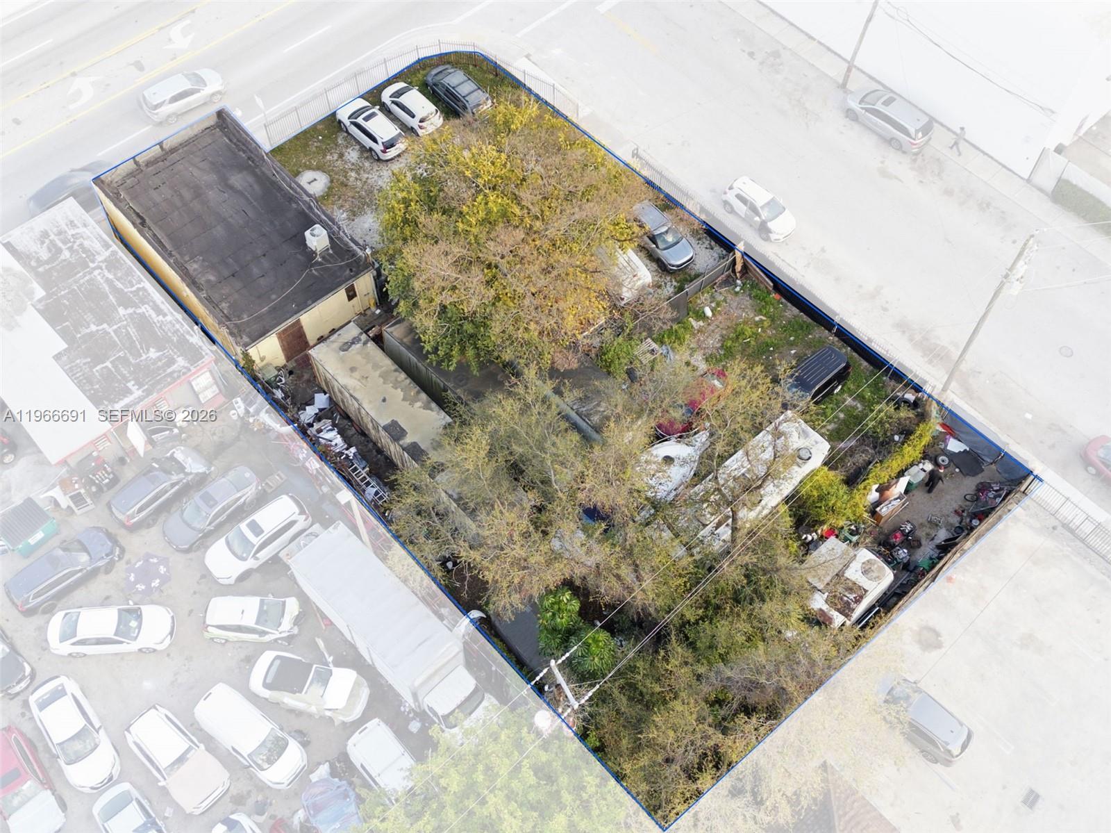 An aerial view shows a fenced lot containing a small building, trees, and parked vehicles — 7010 NW 7th Ave, Miami FL 33150, MIAMI, FL