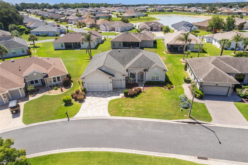 An aerial view shows a suburban house with a gray roof and paved driveway — 10990 SE 170TH STREET ROAD, SUMMERFIELD, FL