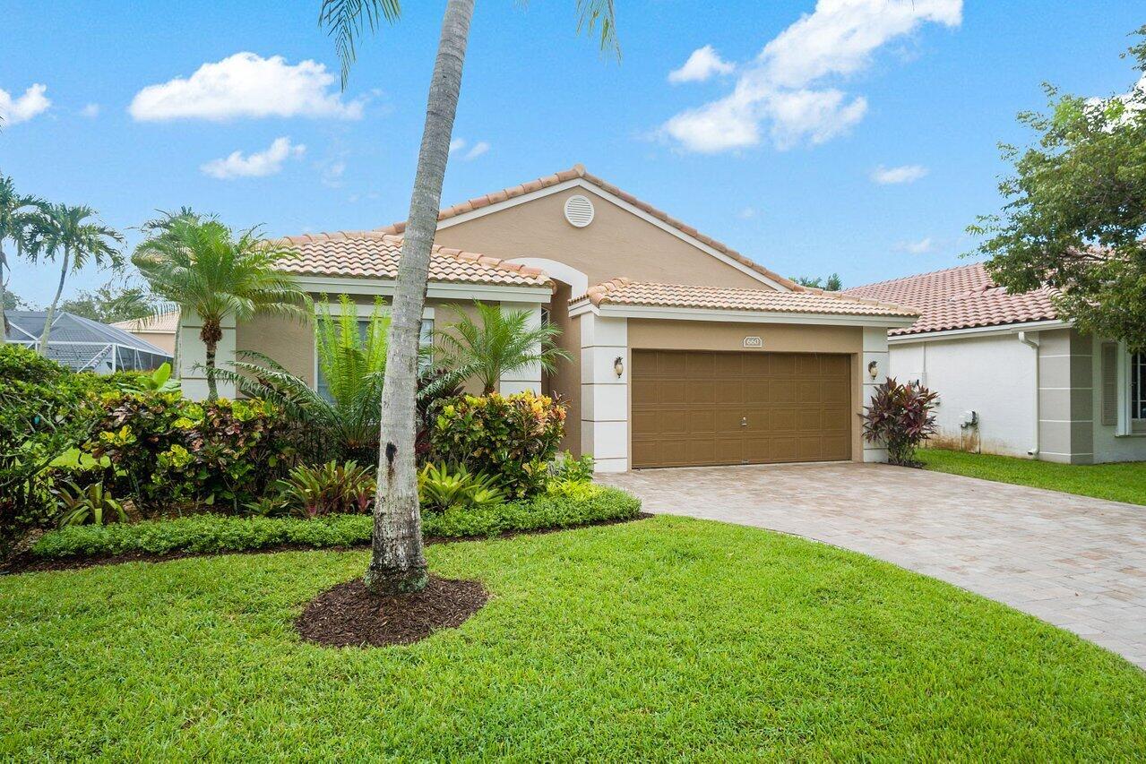 A single-story house with a tan exterior, a brown garage door, and a landscaped front yard — 660 NW 45th Avenue, Deerfield Beach FL 33442, DEERFIELD BEACH, FL