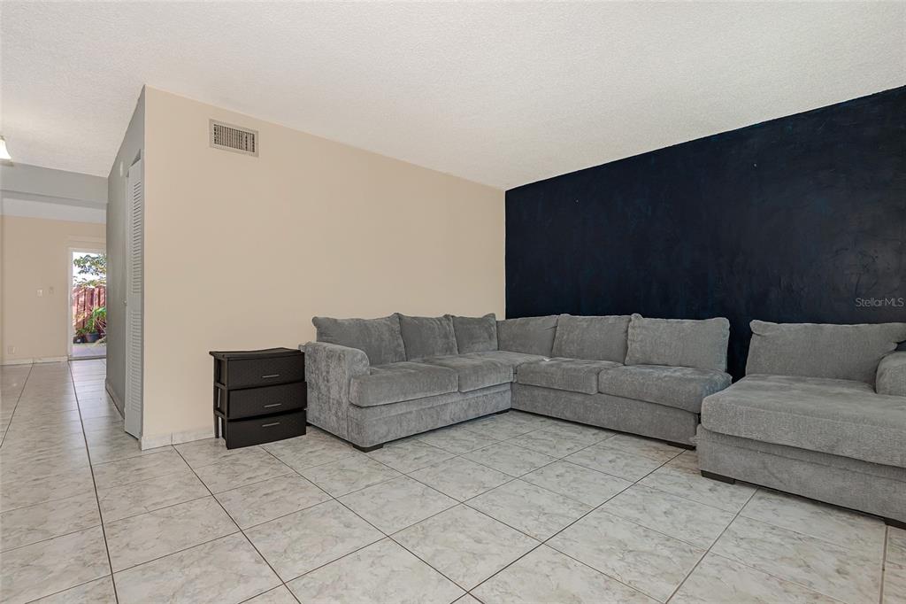 A living room features light tile flooring, a large gray sectional sofa, and a dark wall — 3686 SW 59TH TERRACE UNIT 71, FORT LAUDERDALE, FL