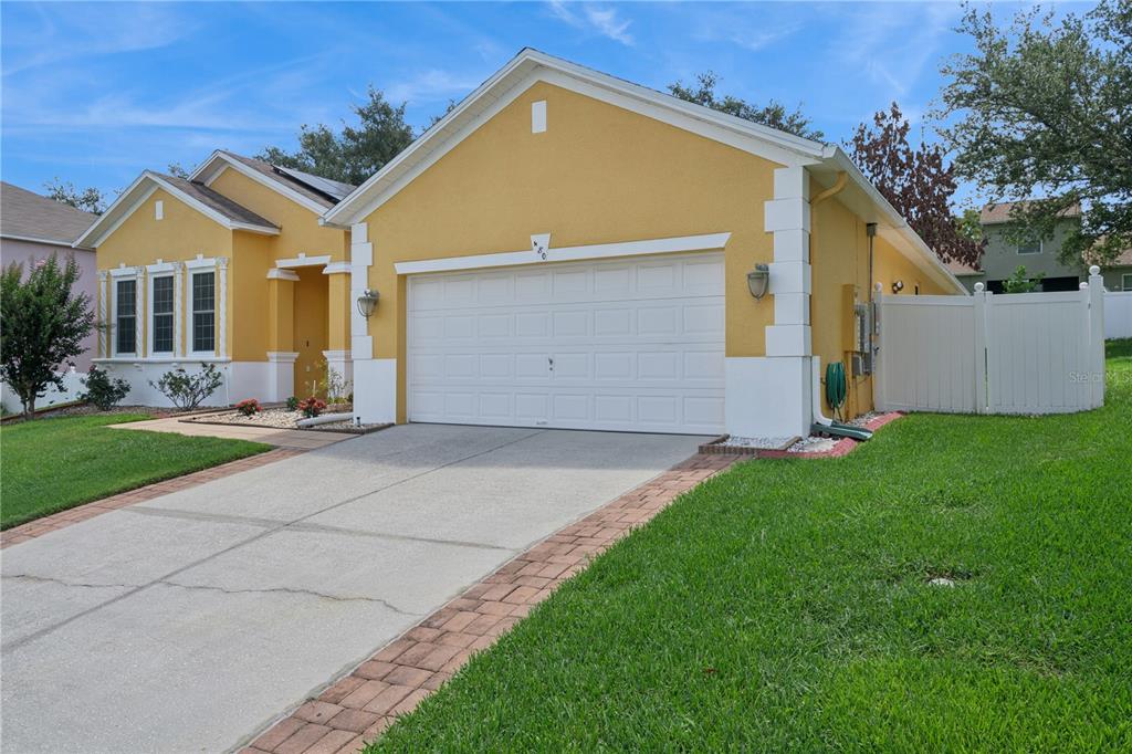 An open-concept kitchen and dining area features light wood cabinets, granite countertops, and tile flooring — 480 ROB ROY DRIVE, CLERMONT, FL