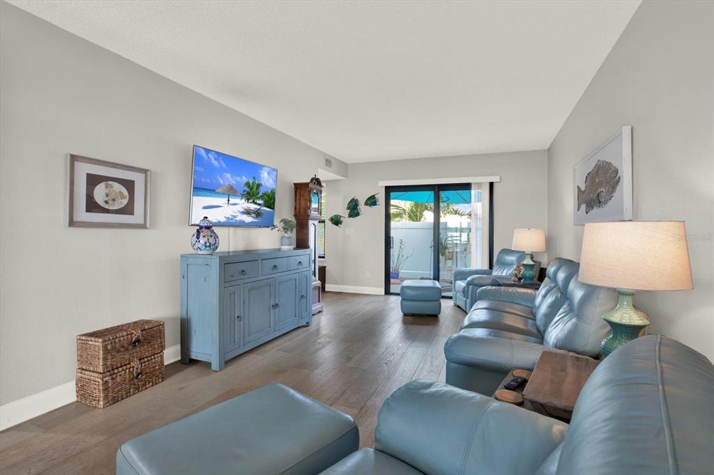 A living room features light blue leather furniture, a blue media console, and wood flooring — 9209 SEMINOLE BOULEVARD UNIT 14, SEMINOLE, FL