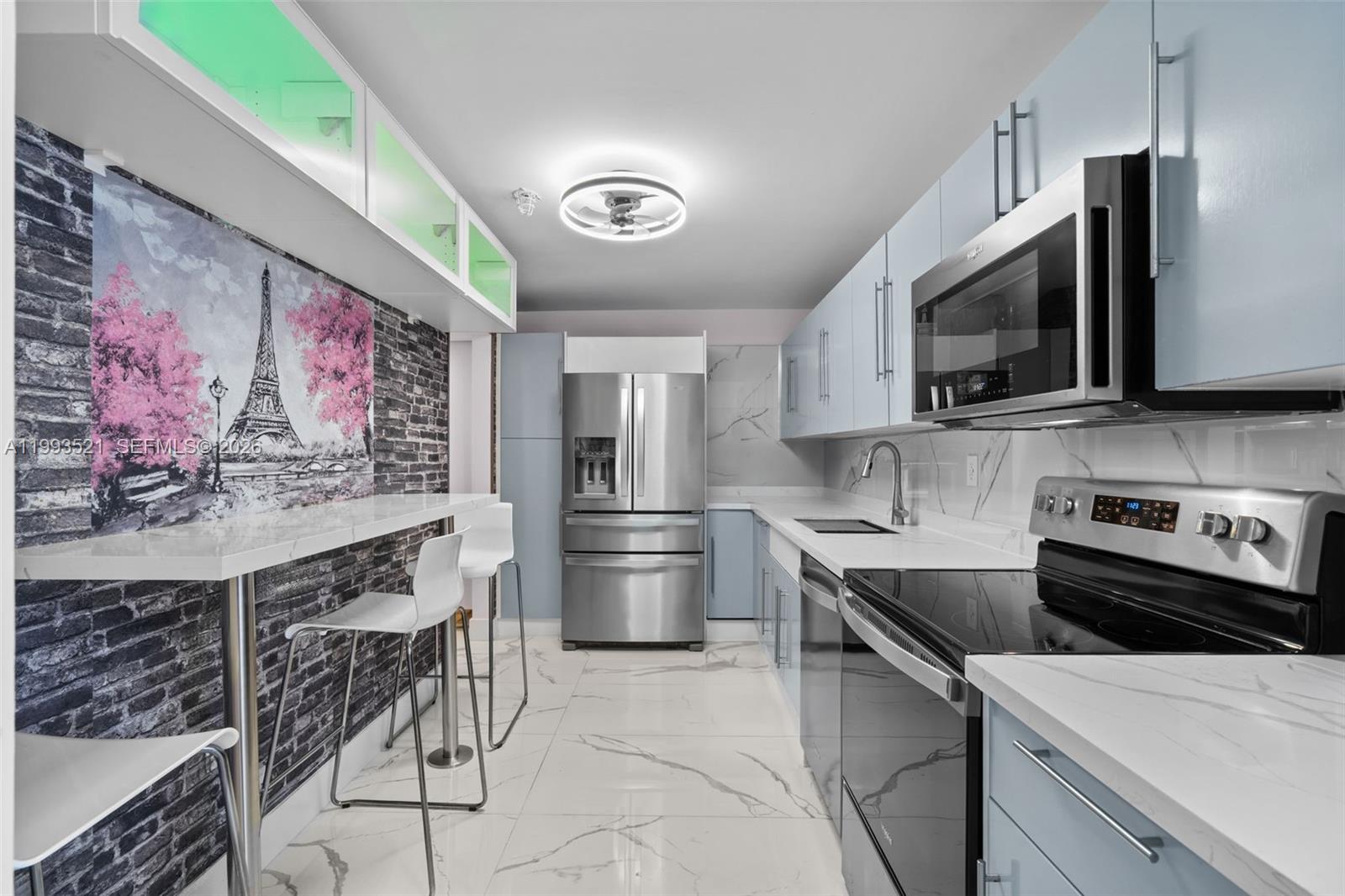 A living room features a white leather sofa, a wall-mounted television, and a glass console — 3000 S Ocean Dr # 606, Hollywood FL 33019, HOLLYWOOD, FL