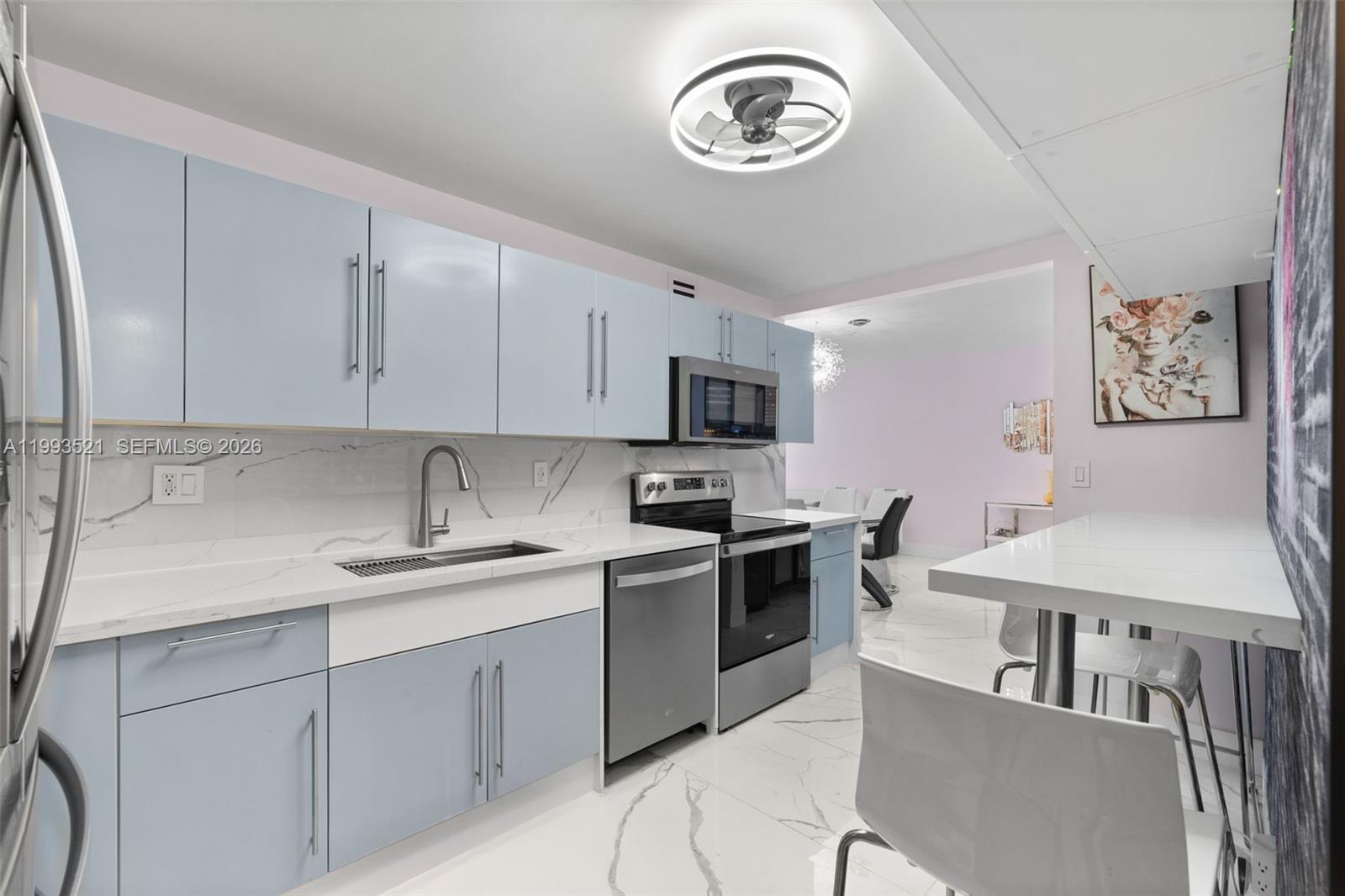 An open-concept living and dining area features white marble floors and modern furniture — 3000 S Ocean Dr # 606, Hollywood FL 33019, HOLLYWOOD, FL