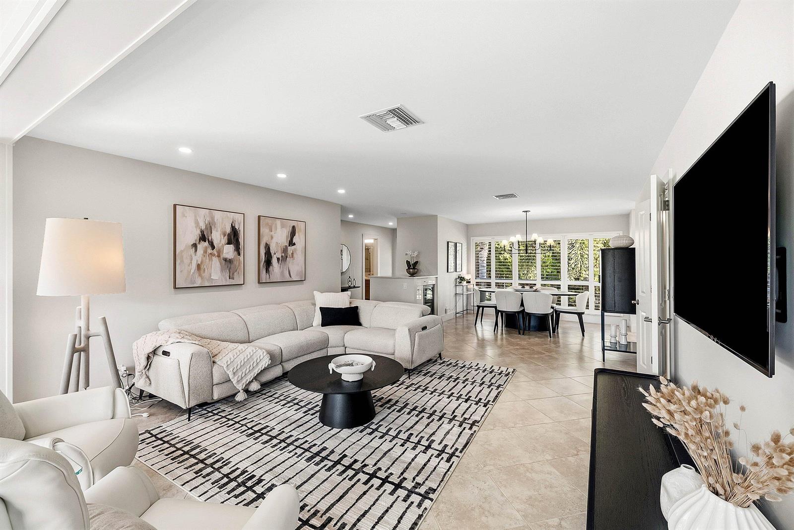 A living room with a sectional sofa, patterned rug, and dining area in the background — 4114 B Quail Ridge Drive N, Boynton Beach FL 33436, BOYNTON BEACH, FL