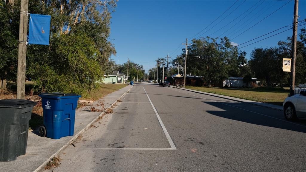 A street view shows a paved road with marked parking spaces, utility poles, and trash bins — 34 4TH STREET SW, FORT MEADE, FL
