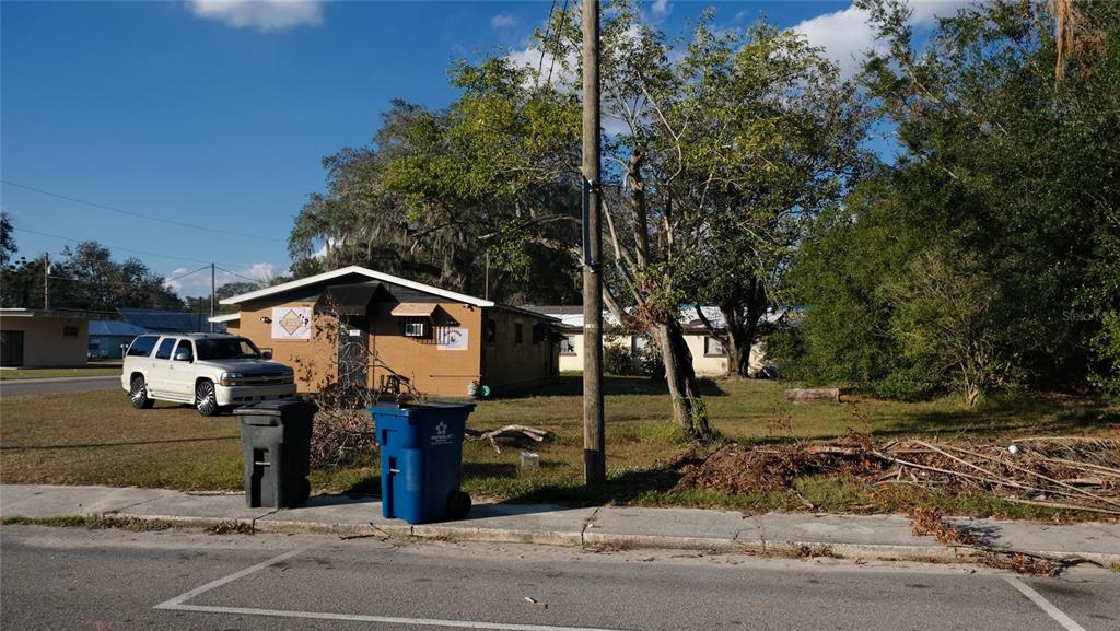 A tan single-story building sits on a grassy lot with a white SUV parked nearby — 34 4TH STREET SW, FORT MEADE, FL