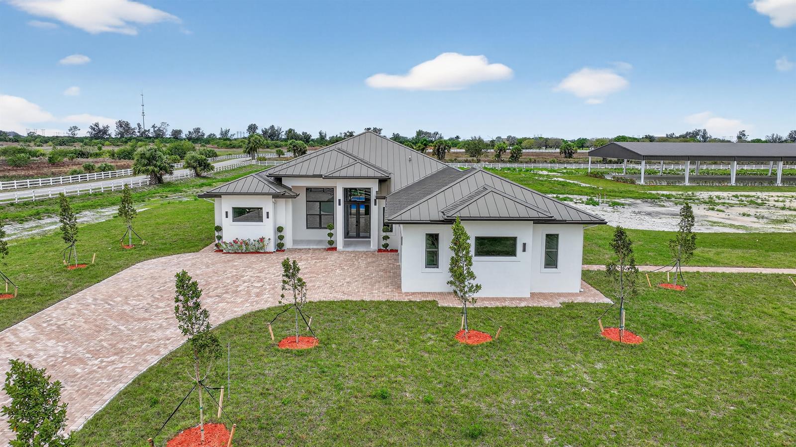 A modern single-story house with a metal roof sits on a large, grassy lot — 3644 Frog Holw, Loxahatchee FL 33470, LOXAHATCHEE, FL