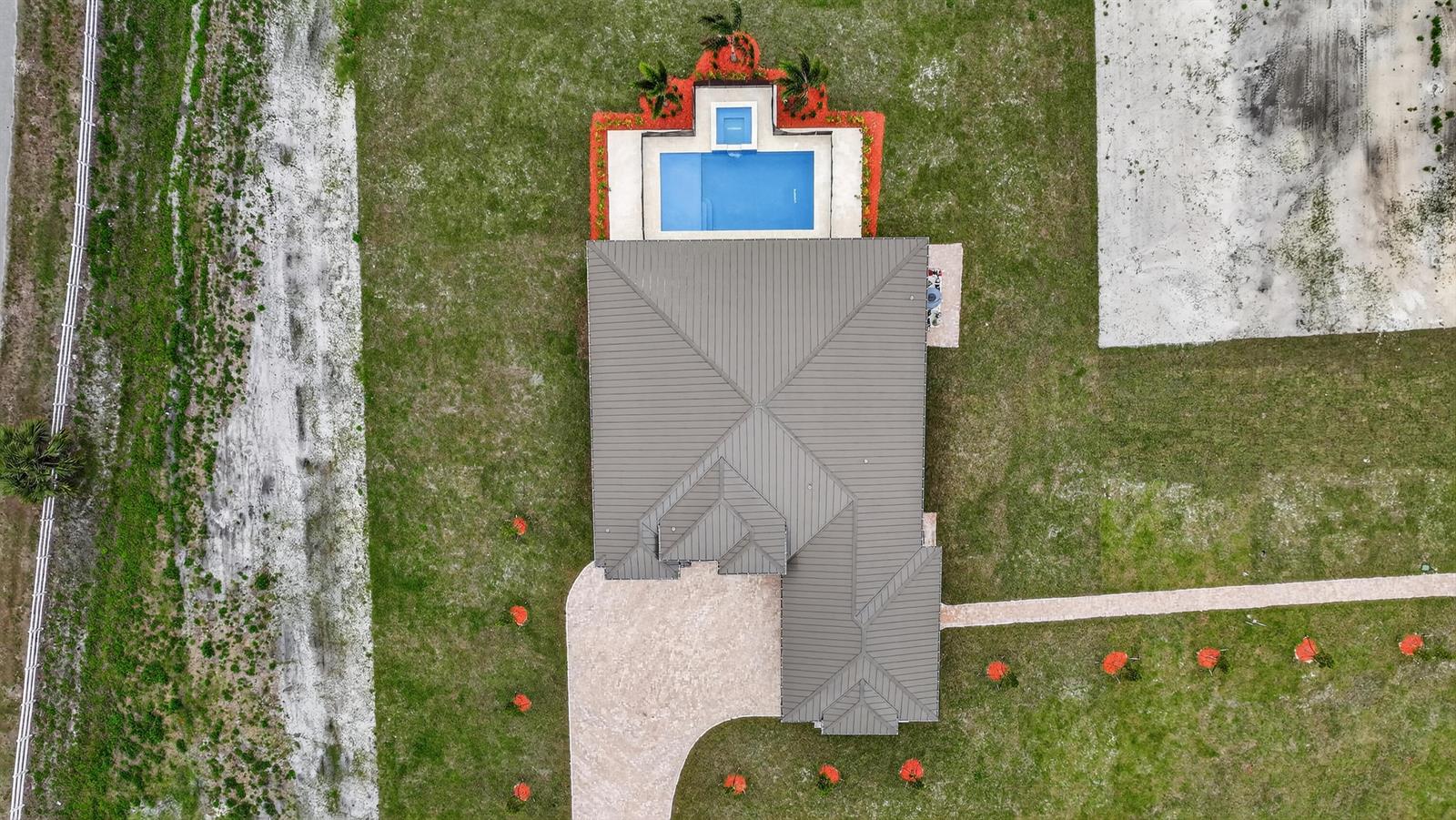 An aerial view shows a house with a metal roof, a pool, and a driveway — 3644 Frog Holw, Loxahatchee FL 33470, LOXAHATCHEE, FL