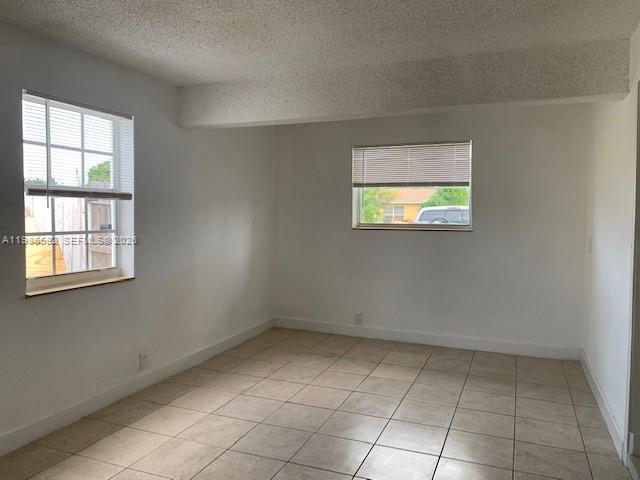An empty room features white walls, a tiled floor, and two windows with blinds — 4930 NW 13th St, Lauderhill FL 33313, LAUDERHILL, FL