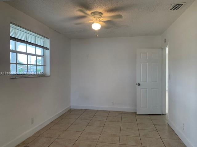An empty room features white walls, a tiled floor, a ceiling fan, and a window — 4930 NW 13th St, Lauderhill FL 33313, LAUDERHILL, FL