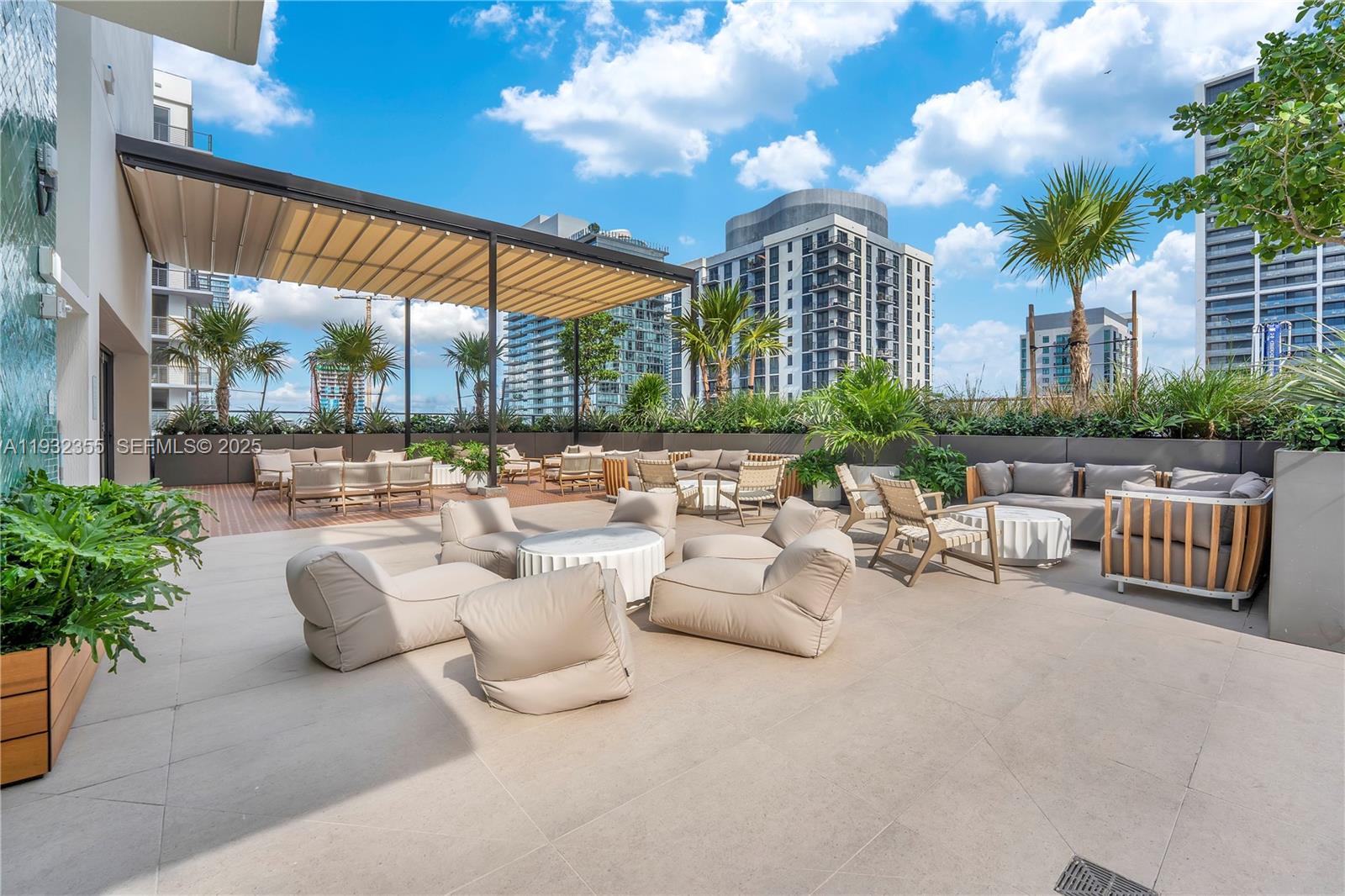 An outdoor rooftop terrace features lounge seating, a retractable canopy, and views of city buildings — 11 NE 6 Street # 2201, Miami FL 33132, MIAMI, FL