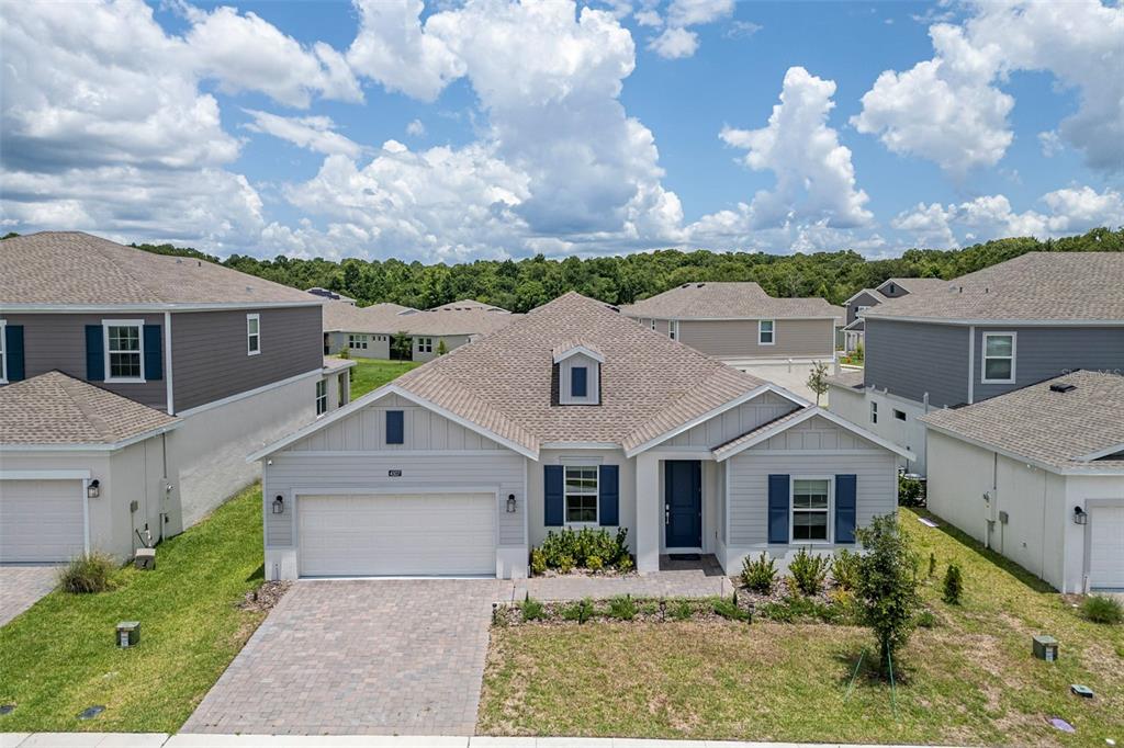 A single-story suburban house features light gray siding, blue shutters, and a paved driveway — 4507 HILLINGDAM ROAD, DAVENPORT, FL