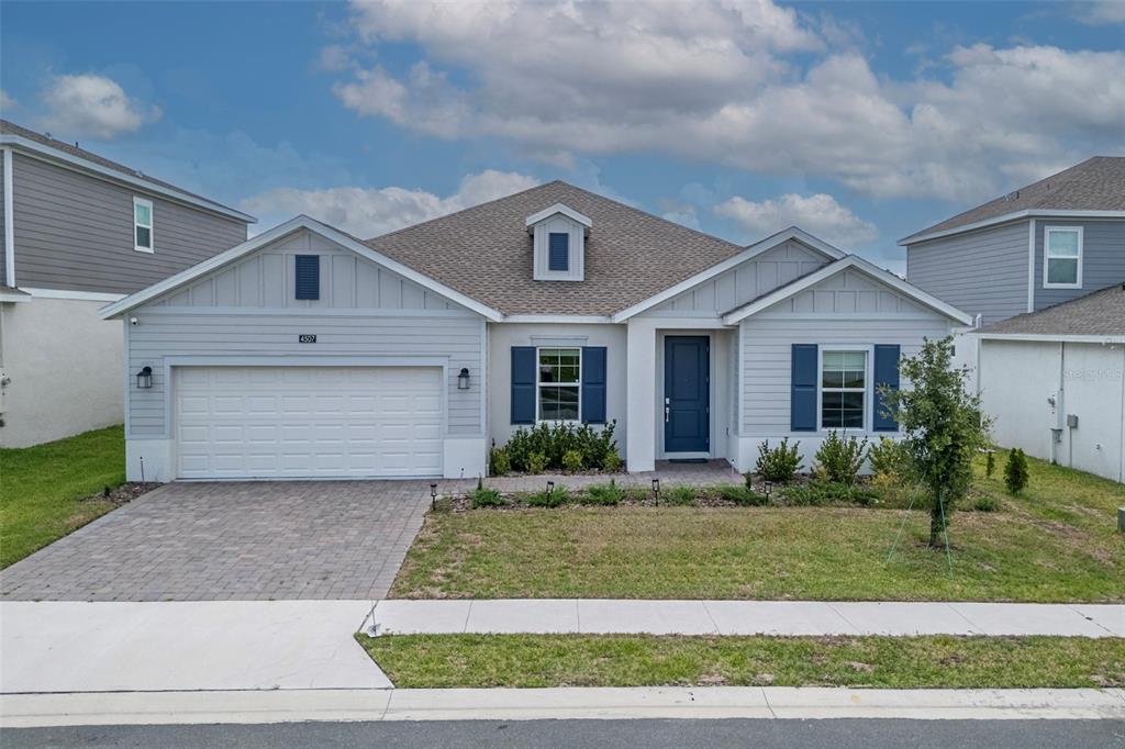 A single-story house with light gray siding, a two-car garage, and blue shutters — 4507 HILLINGDAM ROAD, DAVENPORT, FL