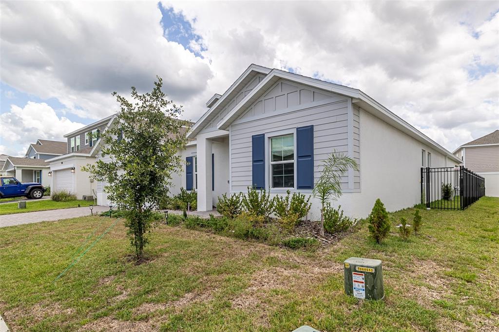 A light gray single-story house with blue shutters and a fenced side yard — 4507 HILLINGDAM ROAD, DAVENPORT, FL