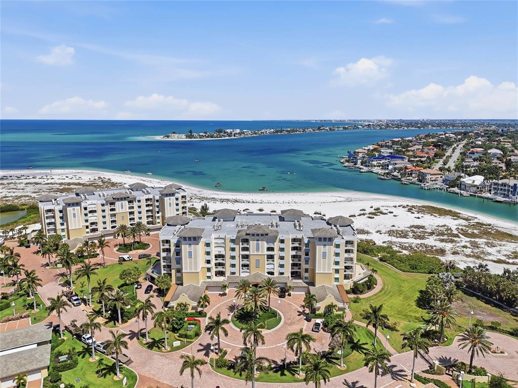 An aerial view of a multi-story residential complex situated on a sandy beach — 650 COLLANY ROAD UNIT 401, TIERRA VERDE, FL