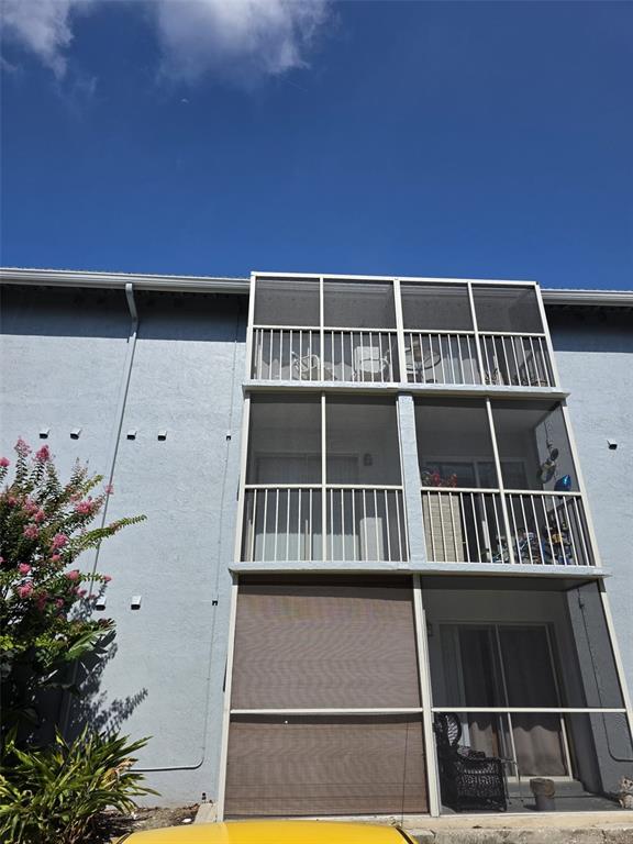 A three-story apartment building exterior features stacked screened-in balconies with a privacy shade on bottom — 139 OYSTER BAY CIRCLE UNIT 220, ALTAMONTE SPRINGS, FL