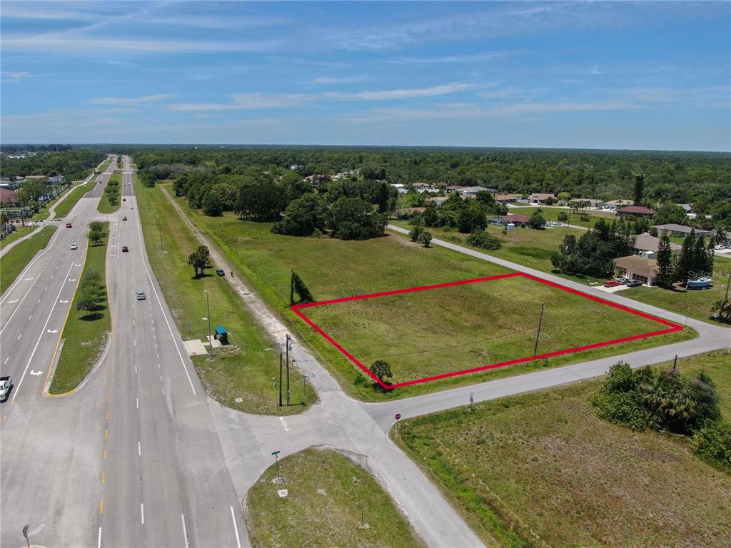 An aerial view shows a vacant rectangular lot outlined in red next to a highway — 11996 TAMIAMI TRAIL S, NORTH PORT, FL