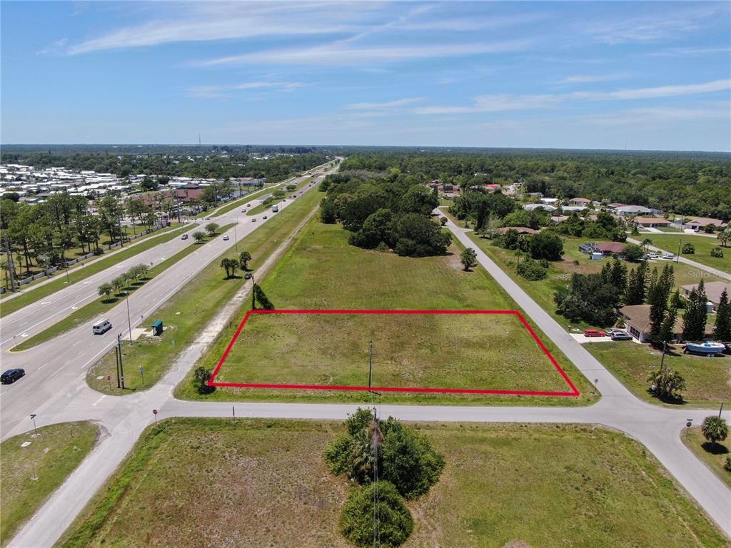 An aerial view shows a rectangular vacant lot outlined in red next to a highway — 11996 TAMIAMI TRAIL S, NORTH PORT, FL