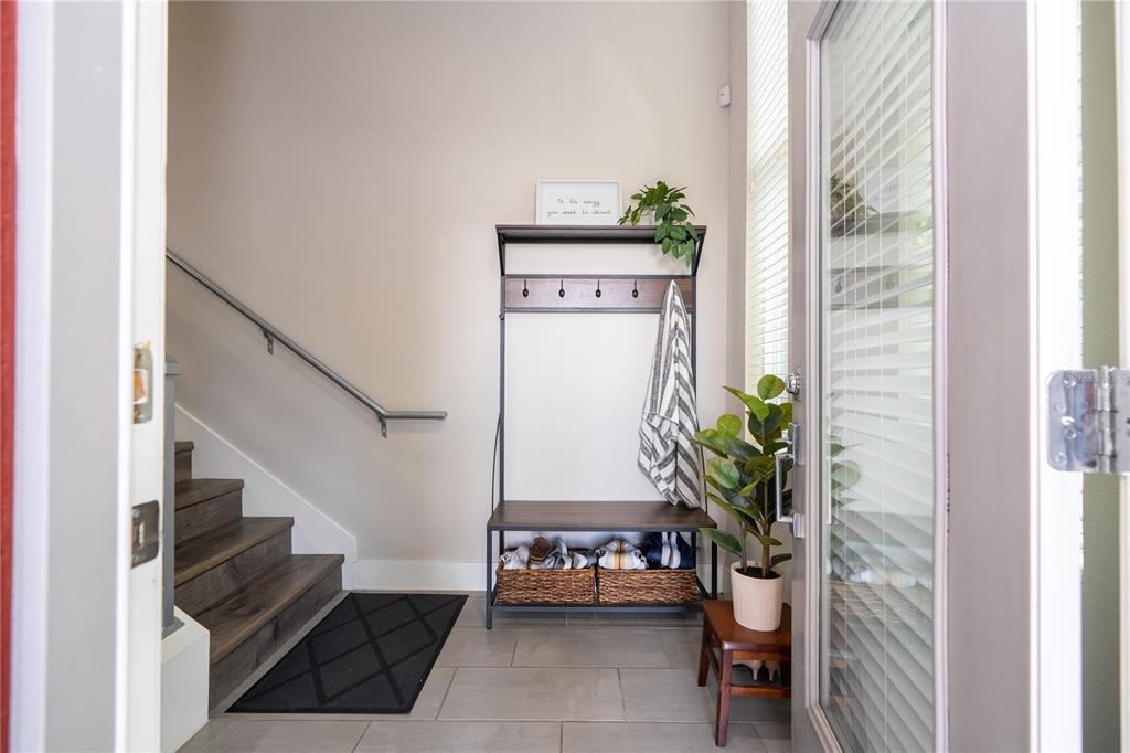 An entryway features a coat rack with a bench, stairs, and a potted plant — 73 W GRANT STREET, ORLANDO, FL