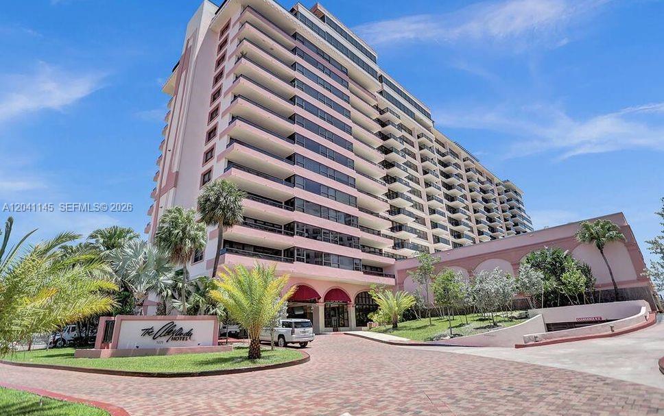 A multi-story pink hotel building stands above a paved driveway with palm trees — 5225 Collins Ave # 914, Miami Beach FL 33140, MIAMI BEACH, FL