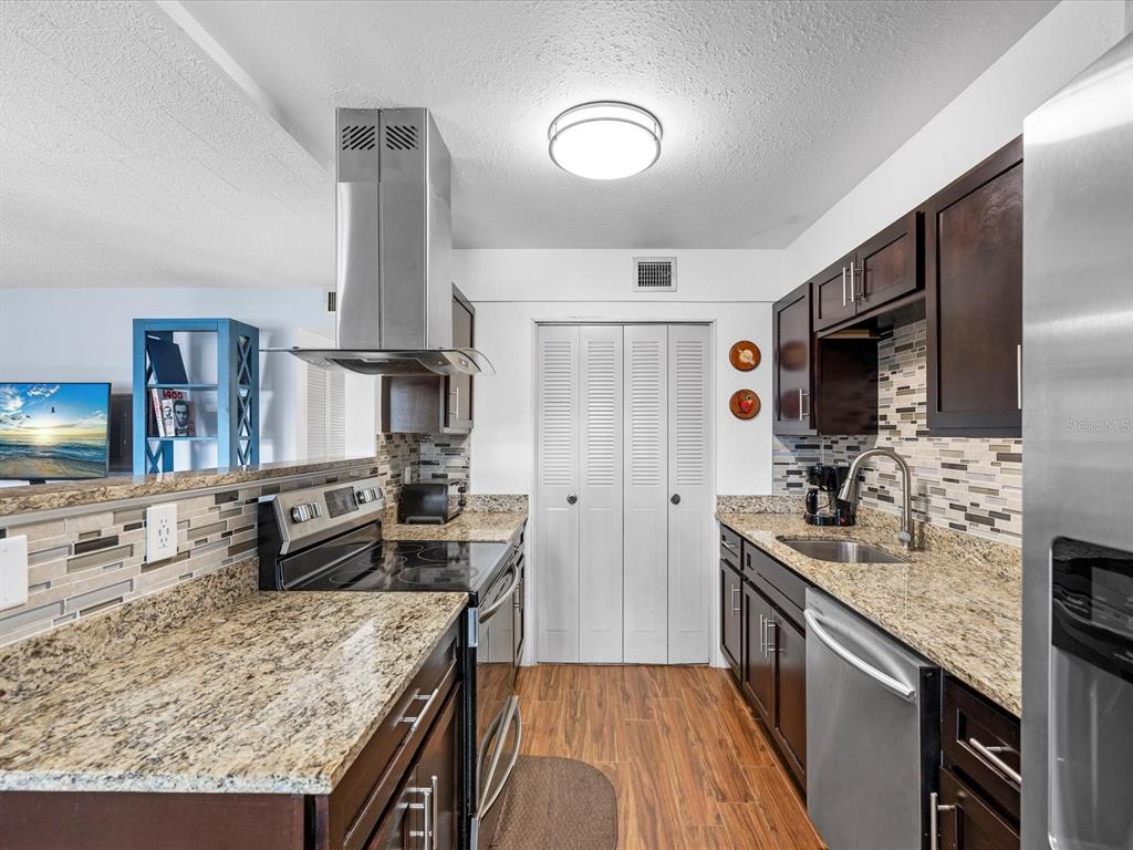 An exterior walkway with a white door labeled 207 and a large window — 1235 S HIGHLAND AVENUE UNIT 2-207, CLEARWATER, FL