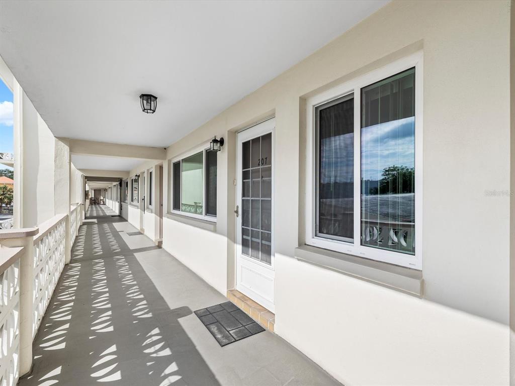 A kitchen features dark wood cabinets, granite countertops, stainless steel appliances, and a tiled backsplash — 1235 S HIGHLAND AVENUE UNIT 2-207, CLEARWATER, FL