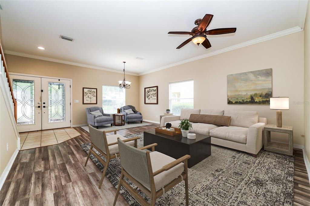 A living room features a beige sofa, two armchairs, a coffee table, and wood flooring — 14831 HERONGLEN DRIVE, LITHIA, FL