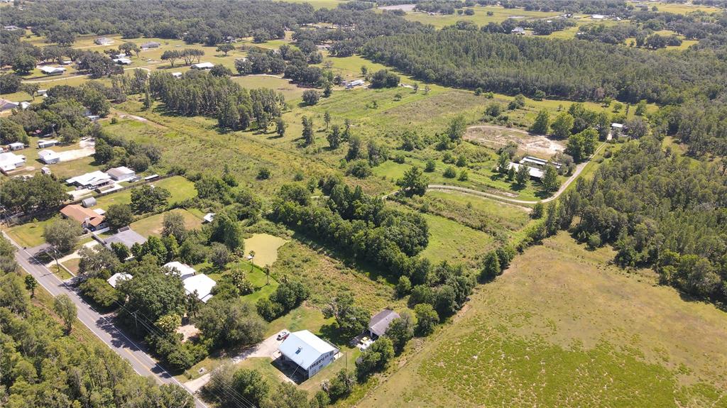 An aerial view shows a rural landscape with scattered houses, wooded areas, and open fields — 4108 COOPER ROAD, PLANT CITY, FL