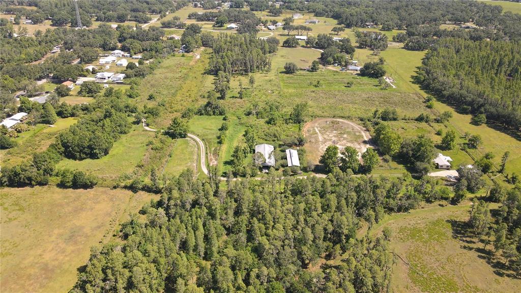 An aerial view shows a rural property with a house, outbuildings, and surrounding wooded land — 4108 COOPER ROAD, PLANT CITY, FL