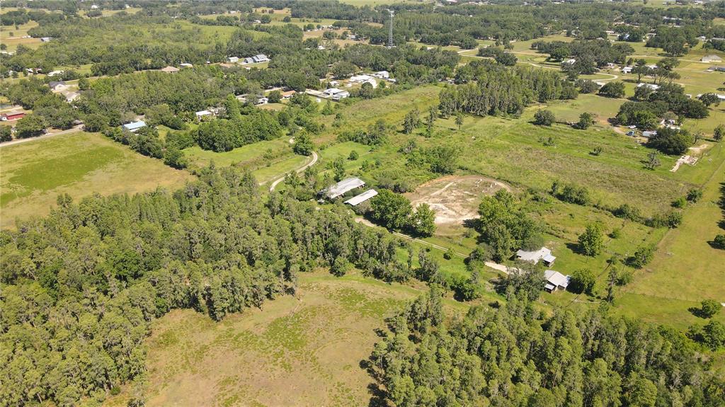 An aerial view shows a rural property with multiple buildings, wooded areas, and open fields — 4108 COOPER ROAD, PLANT CITY, FL