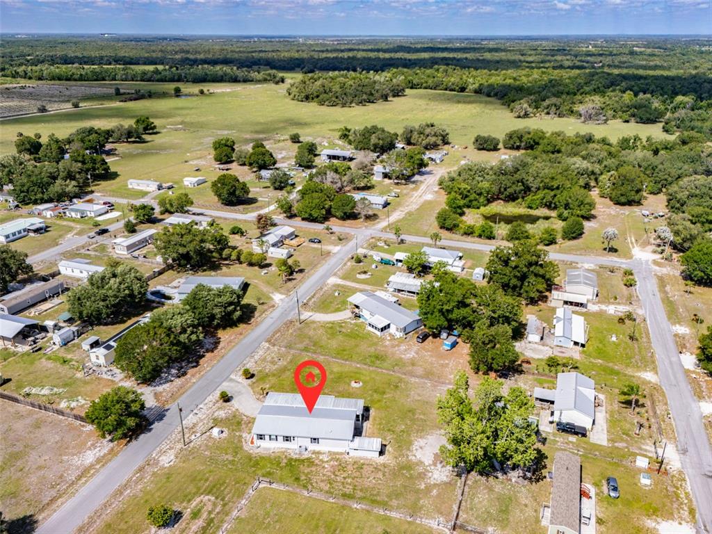 An aerial view shows a single-story house with a red location pin on a lot — 1586 NE GRAPEFRUIT STREET, ARCADIA, FL