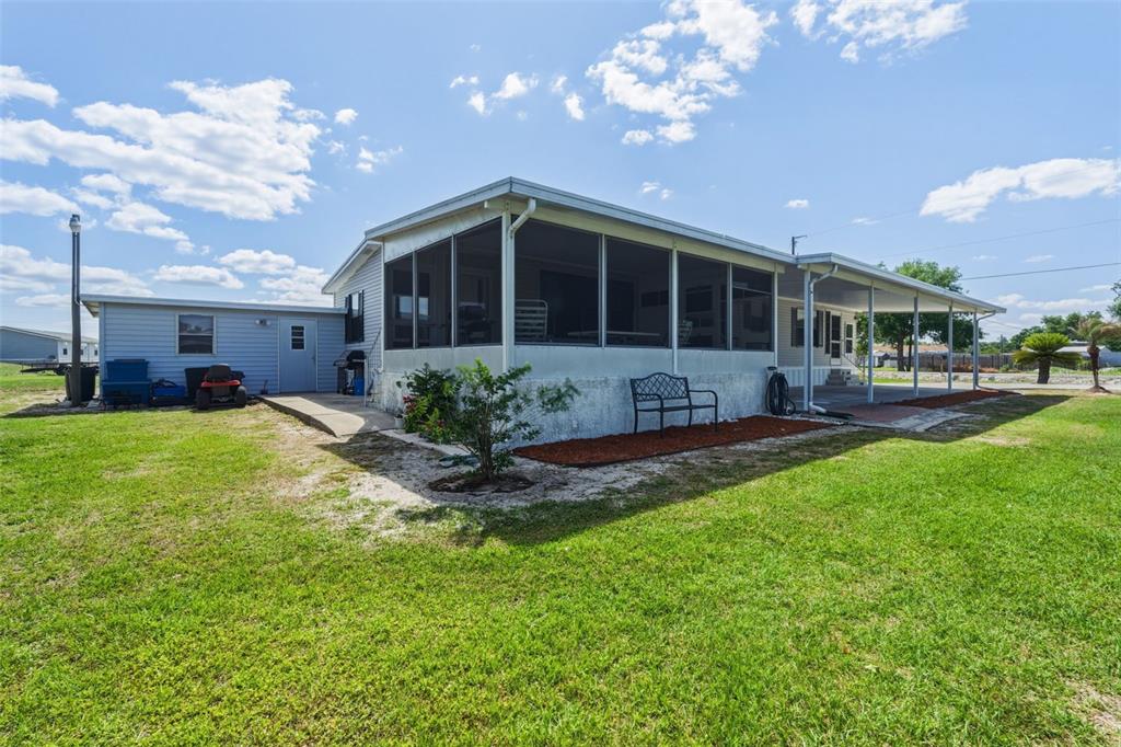A mobile home with a screened-in porch, a carport, and a detached storage shed — 1586 NE GRAPEFRUIT STREET, ARCADIA, FL