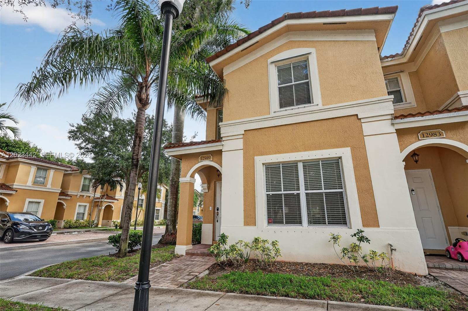 A two-story tan stucco townhouse with a tiled roof and a brick walkway entrance — 12989 SW 30th Ct # 135, Miramar FL 33027, MIRAMAR, FL