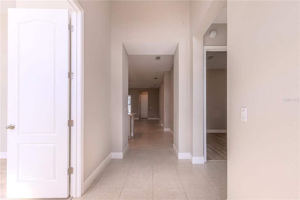 A view down a tiled hallway leading toward an open-concept living area — 9233 SMITHIES STREET, ORLANDO, FL