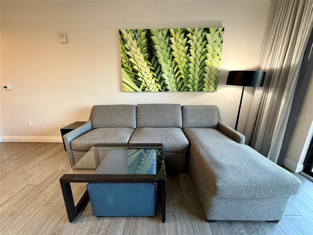 A living room features a gray sectional sofa, a glass coffee table, and botanical wall art — 14501 GROVE RESORT AVE UNIT 2413, WINTER GARDEN, FL