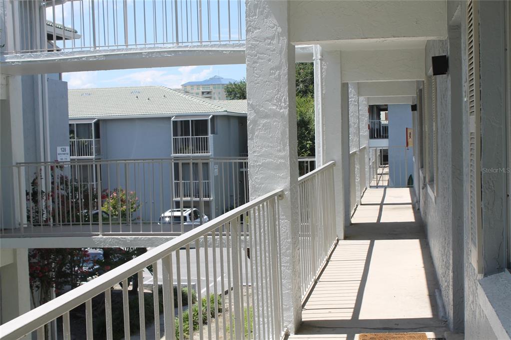 An outdoor walkway with white railings overlooks a parking area and a neighboring apartment building — 151 OYSTER BAY CIRCLE UNIT 200, ALTAMONTE SPRINGS, FL