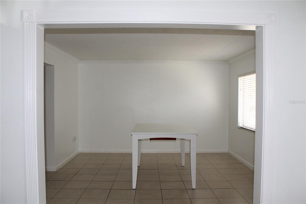 A dining room with white walls, tile flooring, and a white table centered in the space — 151 OYSTER BAY CIRCLE UNIT 200, ALTAMONTE SPRINGS, FL