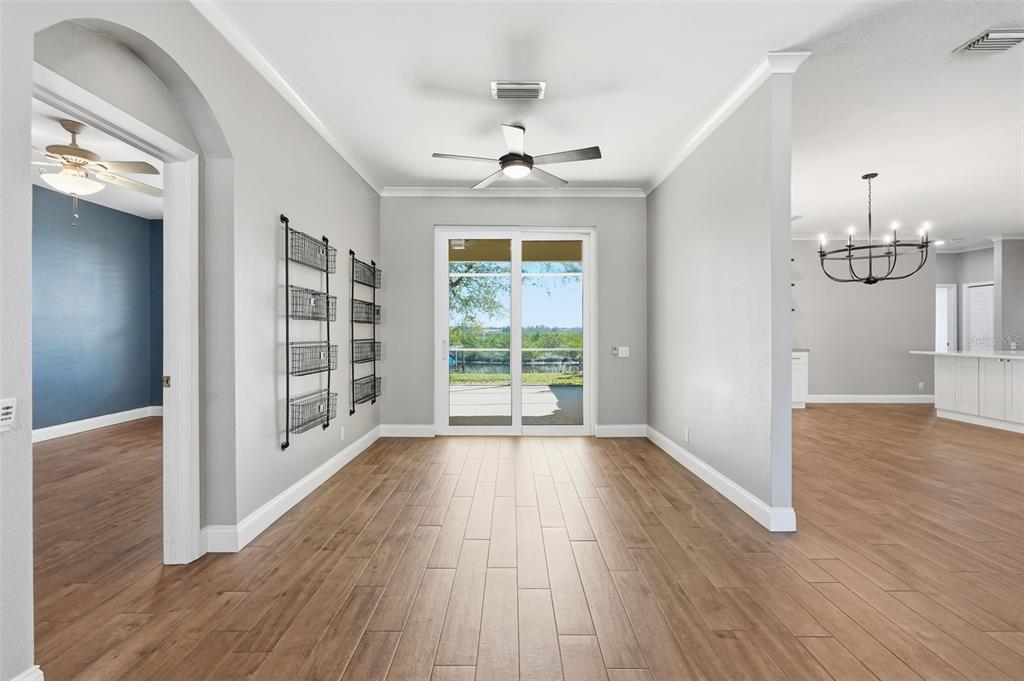 A dining area with wood-look tile floors, a ceiling fan, and sliding glass doors — 1857 RIVEREDGE DRIVE, TARPON SPRINGS, FL