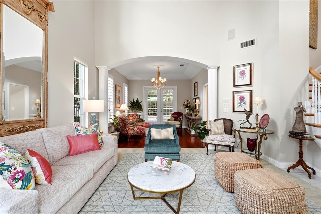 A living room features a marble coffee table, a blue armchair, and a large mirror — 1246 DARLINGTON OAK CIRCLE NE, ST PETERSBURG, FL
