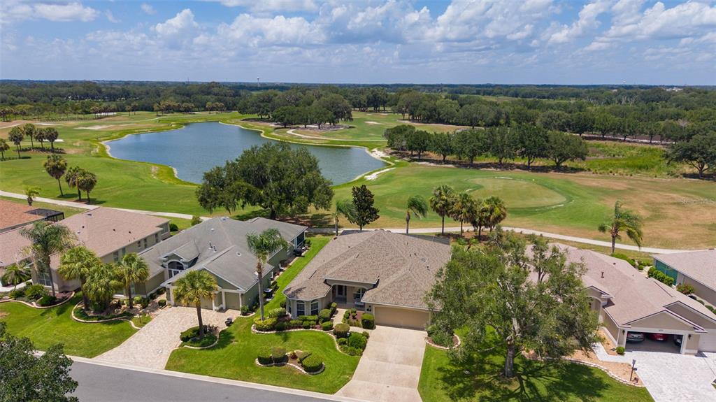 A single-story tan house with a hip roof, arched windows, and manicured landscaping — 1281 BETHUNE WAY, THE VILLAGES, FL